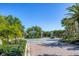 Community entrance with mature trees, lush landscaping and brick-paved roads giving an opulent feel at 27454 Hole In One Pl, Englewood, FL 34223
