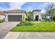 Beautiful single Gathering home with a two-car garage and meticulously landscaped yard on a sunny day at 27454 Hole In One Pl, Englewood, FL 34223