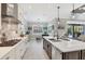 Bright kitchen features an island with barstool seating, gas range and stainless appliances and backyard view at 27454 Hole In One Pl, Englewood, FL 34223