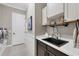 Modern laundry room with white cabinets, stainless steel appliances, and a stylish sink at 27454 Hole In One Pl, Englewood, FL 34223