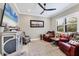 Comfortable living room with decorative furnishings, a ceiling fan, and a large-screen television at 27454 Hole In One Pl, Englewood, FL 34223