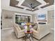Bright living room with access to the pool offers cozy seating and sophisticated decor with natural light at 27454 Hole In One Pl, Englewood, FL 34223