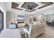 Comfortable living room features an elegant tray ceiling, recessed lighting, fireplace, and plush seating at 27454 Hole In One Pl, Englewood, FL 34223