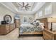 Spacious bedroom features tray ceiling, ceiling fan, and tiled floors at 27454 Hole In One Pl, Englewood, FL 34223