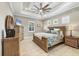 Comfortable bedroom features a tray ceiling, ceiling fan, and tiled floor at 27454 Hole In One Pl, Englewood, FL 34223
