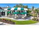 Inviting outdoor patio with ample seating, shade, and lush landscaping at 27454 Hole In One Pl, Englewood, FL 34223