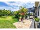 Landscaped backyard patio with tropical plants and access to the screened pool area at 27454 Hole In One Pl, Englewood, FL 34223