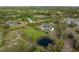 Estate aerial view showing ponds, a manicured lawn, mature landscaping, and private wooded areas at 30416 Saddlebag Trl, Myakka City, FL 34251