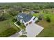 An aerial shot displays a well-manicured lawn, beautiful landscaping, and a spacious three-car driveway at 30416 Saddlebag Trl, Myakka City, FL 34251