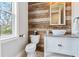 Charming powder room with rustic wood wall accents, modern vanity, and patterned tile floor at 30416 Saddlebag Trl, Myakka City, FL 34251