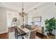 Bright dining room with wood floors, a modern chandelier, shiplap wall, and view into the foyer at 30416 Saddlebag Trl, Myakka City, FL 34251