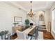 Inviting dining room boasts wood floors, modern chandelier, shiplap accent wall, and staircase access at 30416 Saddlebag Trl, Myakka City, FL 34251