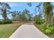 Long paved driveway leading to a property surrounded by mature trees and lush landscaping at 30416 Saddlebag Trl, Myakka City, FL 34251