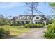 Beautiful two-story home with manicured lawn, mature trees, and a welcoming entrance at 30416 Saddlebag Trl, Myakka City, FL 34251