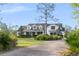 Charming two-story home with a manicured lawn and mature landscaping at 30416 Saddlebag Trl, Myakka City, FL 34251