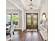 Welcoming foyer features wood floors, double doors, tray ceiling, and decor on a white console table at 30416 Saddlebag Trl, Myakka City, FL 34251