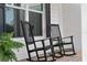 Classic black rocking chairs on a charming front porch with white siding and black shutters at 30416 Saddlebag Trl, Myakka City, FL 34251