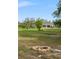 Expansive front yard featuring a fire pit and a charming single-story home with a covered porch at 30416 Saddlebag Trl, Myakka City, FL 34251