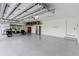 Spacious three-car garage features a golf cart, workstation, storage, and epoxy flooring at 30416 Saddlebag Trl, Myakka City, FL 34251