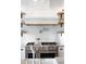Elegant kitchen showcasing a stainless steel range, pot filler, and white subway tile backsplash with open shelving at 30416 Saddlebag Trl, Myakka City, FL 34251