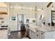 Well-lit kitchen showcasing stainless steel appliances, and custom cabinetry with glass accents at 30416 Saddlebag Trl, Myakka City, FL 34251