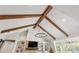 Spacious living room boasts high ceilings with wood beams and a brick fireplace with integrated shelving at 30416 Saddlebag Trl, Myakka City, FL 34251