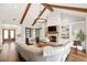 Open living room boasts wood beams, a fireplace, and sliding barn doors at 30416 Saddlebag Trl, Myakka City, FL 34251