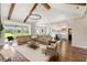 Open-concept living space featuring hardwood floors, vaulted ceilings, exposed beams, and modern lighting at 30416 Saddlebag Trl, Myakka City, FL 34251