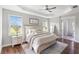 Bright main bedroom showcasing a decorative ceiling, wood floors, and stylish furnishings at 30416 Saddlebag Trl, Myakka City, FL 34251