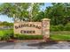 A stone community sign that reads Saddlebag Creek is showcased with healthy, trimmed bushes at 30416 Saddlebag Trl, Myakka City, FL 34251