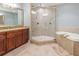 Bathroom showcasing a glass-enclosed shower, soaking tub, and granite countertops, offering a luxurious experience at 3420 77Th W St # 202, Bradenton, FL 34209