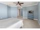 Bedroom featuring blue walls, white trim, ceiling fan, and television stand, creating a relaxing atmosphere at 3420 77Th W St # 202, Bradenton, FL 34209