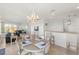 Bright dining area with a chandelier, table seating four, and an open view into the living room at 3420 77Th W St # 202, Bradenton, FL 34209