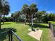 Community dog park featuring lush green space, mature palm trees, a dog water fountain, and benches at 3420 77Th W St # 202, Bradenton, FL 34209