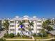 Attractive exterior view of condo building with white balconies, palm trees, and lush landscaping at 3420 77Th W St # 202, Bradenton, FL 34209