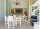 Stylish outdoor dining area with a modern grill, large table, and mounted TV for comfortable entertaining at 3420 77Th W St # 202, Bradenton, FL 34209
