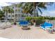 Inviting outdoor seating area with comfortable blue couches, a fire pit, and lush landscaping creating a relaxing ambiance at 3420 77Th W St # 202, Bradenton, FL 34209