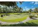 Beautiful putting green surrounded by lush landscaping and mature trees, perfect for leisurely outdoor activities at 3420 77Th W St # 202, Bradenton, FL 34209
