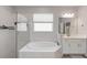 Bright bathroom features a soaking tub, glass shower, and white vanity with sink at 3619 Quiet Dr, Sarasota, FL 34240