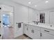Bright bathroom with dual sinks, white cabinets, a large mirror, and access to a walk-in closet at 3725 Spyglass Hill Rd, Sarasota, FL 34238