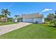 Well-maintained home features a brick driveway, manicured lawn, and classic architectural details at 3725 Spyglass Hill Rd, Sarasota, FL 34238