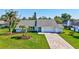 Charming single-story home boasting a manicured lawn, brick driveway, and tropical landscaping with mature palm trees at 3725 Spyglass Hill Rd, Sarasota, FL 34238