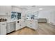 Charming kitchen with stainless appliances, white cabinets and an open window showcasing the beautiful backyard at 3725 Spyglass Hill Rd, Sarasota, FL 34238