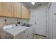 Practical laundry room with washer, dryer, and overhead cabinets for efficient storage and organization at 3725 Spyglass Hill Rd, Sarasota, FL 34238