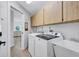 Functional laundry area features a washer, dryer, utility sink, and ample cabinet space for convenience at 3725 Spyglass Hill Rd, Sarasota, FL 34238