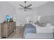 This spacious main bedroom has neutral tones, a ceiling fan, and a large dresser with a TV at 3725 Spyglass Hill Rd, Sarasota, FL 34238