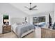Bedroom with view of screened pool, light grey textiles and decorative nightstand at 3725 Spyglass Hill Rd, Sarasota, FL 34238