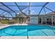Inviting screened pool area featuring an outdoor dining space, lounge seating, and serene backyard views at 3725 Spyglass Hill Rd, Sarasota, FL 34238