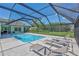 A covered pool with lounge chairs and pristine, crystal clear water at 3725 Spyglass Hill Rd, Sarasota, FL 34238