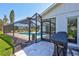 Inviting pool area under a screened enclosure with patio furniture and outdoor grill, perfect for entertaining at 3725 Spyglass Hill Rd, Sarasota, FL 34238